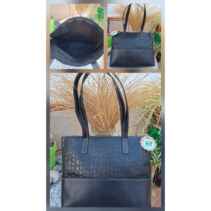 Interior forrado de un bolso artesanal negro con bolsillos organizadores y cierre de cremallera.