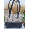 Vista posterior de bolso artesanal premium con grabado de serpiente metalizado y costuras blancas claras hechas a mano.