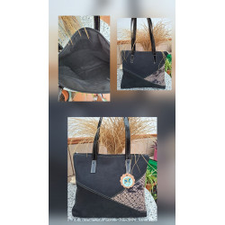 Composición bolso tote de autor en piel negra combinado con un panel inferior asimétrico de grabado efecto pitón hecho España.