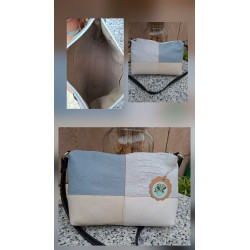 Composición bolso bandolera de autor piel diseño patchwork tonos azul cielo beige y blanco texturas grabadas e interior forrado.