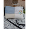 Vista frente bandolera piel de autor diseño cuatro cuadrantes colores azul pastel, crema, blanco grabado cocodrilo, correa negra