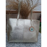 Vista frente bolso hombro tipo tote piel auténtica metalizada color dorado textura granulada costura central unión artesanal.