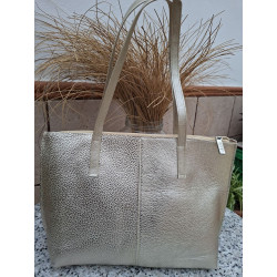 Vista trasera bolso hombro tipo tote piel auténtica metalizada dorada, mostrando cierre superior cremallera y asas cosidas.